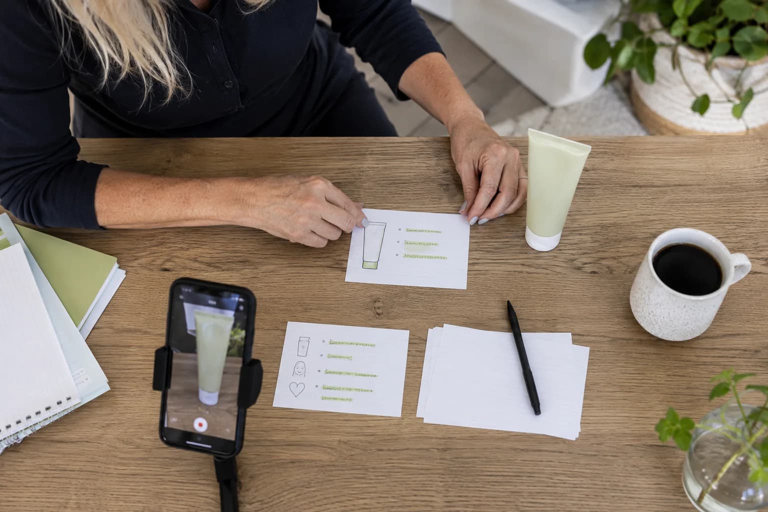 A creator organizing product notes beside a phone ready to film
